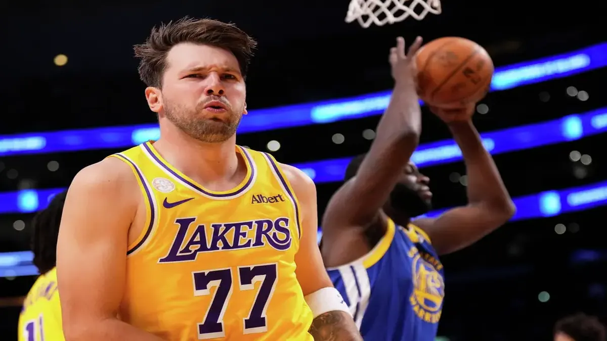 The Lakers’ Luka Doncic, who scored 28 points, looks to fans after scoring as the Warriors’ Draymond Green takes the ball during the first half Wednesday in Los Angeles.