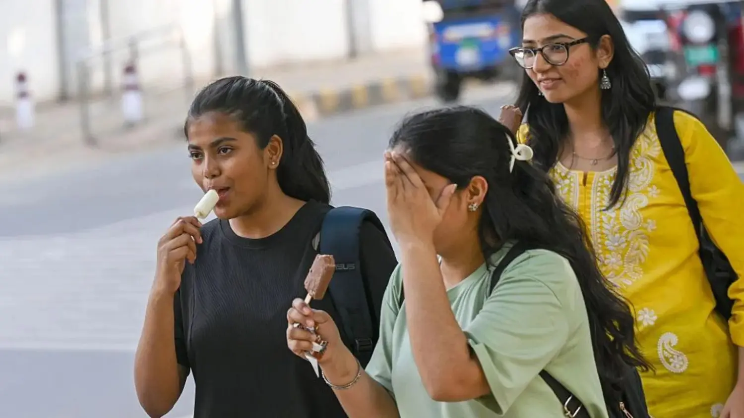 Some college students eating ice cream during the summer.