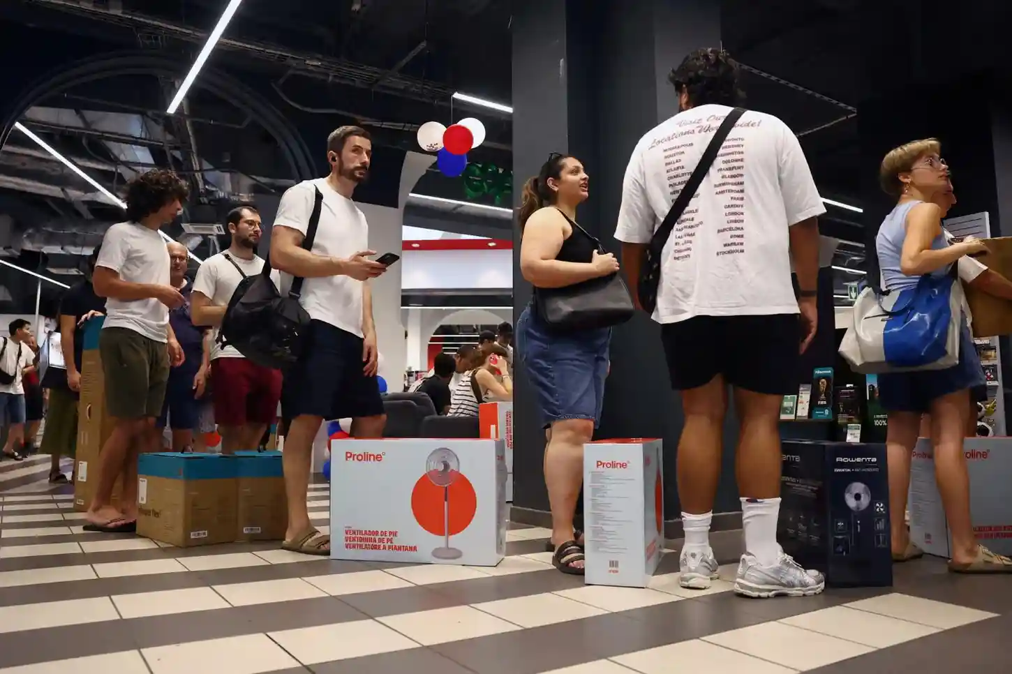 People queue to buy pedestal fans and humidifiers at a Paris electronics and homeware store as temperatures rise.