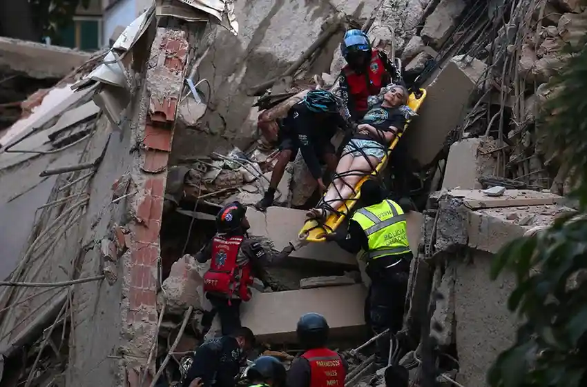 Rescue workers carry a person on a stretcher out of a collapsed building following an earthquake in Caracas on June 24, 2026.