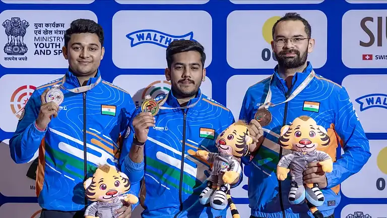 Indian shooters pose with medals and Asian Games mascots after winning medals at the shooting event