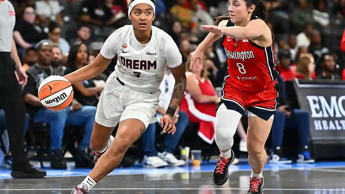 Atlanta Dream player drives toward the basket while a Washington Mystics defender contests the play during a WNBA game.