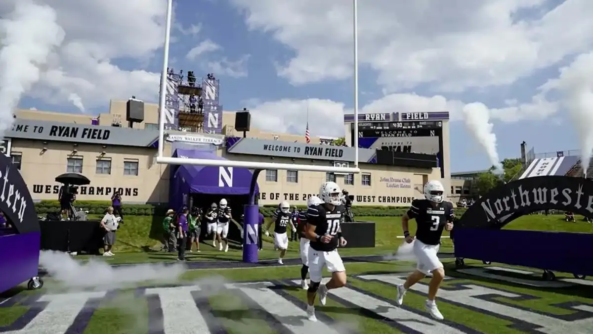 Northwestern football players run onto the field through the Ryan Field entrance before a game