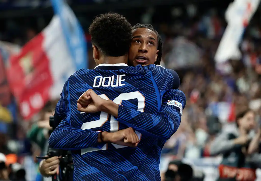 Michael Olise embraces Désiré Doué after scoring France’s third goal of the game.
