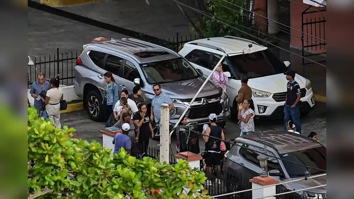 People gather outside a CSS Panama facility beneath a sign reading “Humanizándonos.”