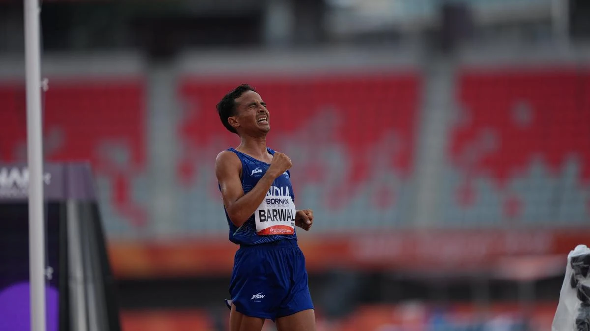 Indian runner Barwal celebrates after finishing an Asian Games race