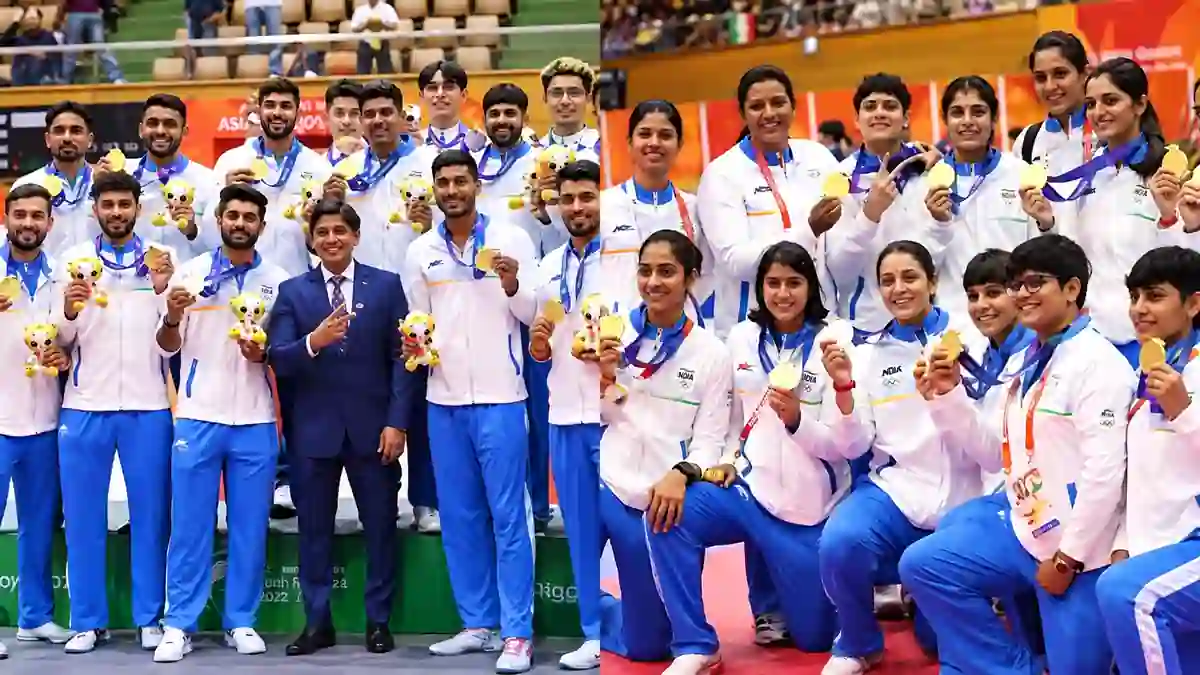 Indian men’s and women’s teams posing together at an Asian Games medal ceremony, wearing India tracksuits and displaying gold medals and mascot toys.