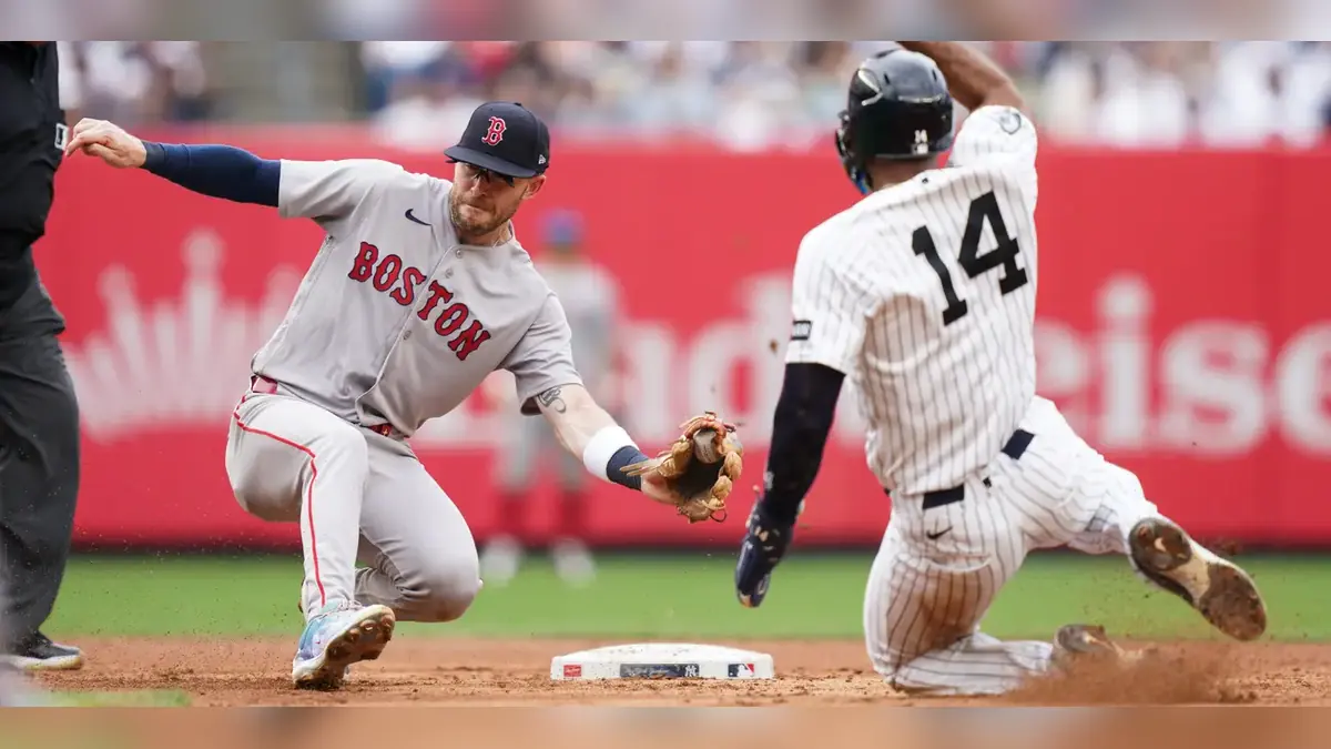 Boston Red Sox player attempts to tag New York Yankees runner at second base during an MLB game.