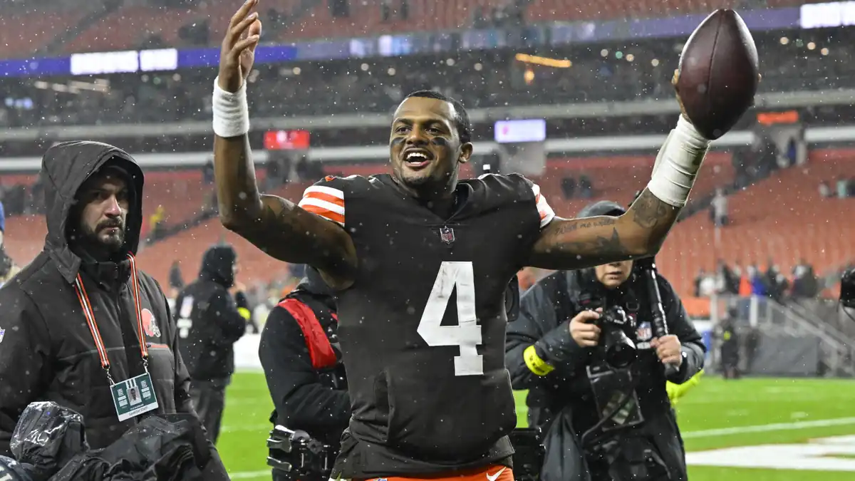 Deshaun Watson of the Cleveland Browns celebrating with a football in the rain during an NFL game