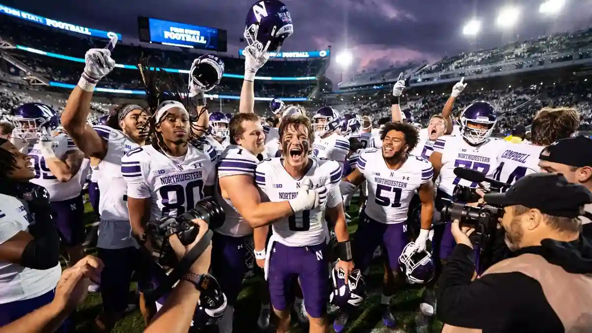 Northwestern Wildcats football players celebrate together on the field after a victory at Ryan Field