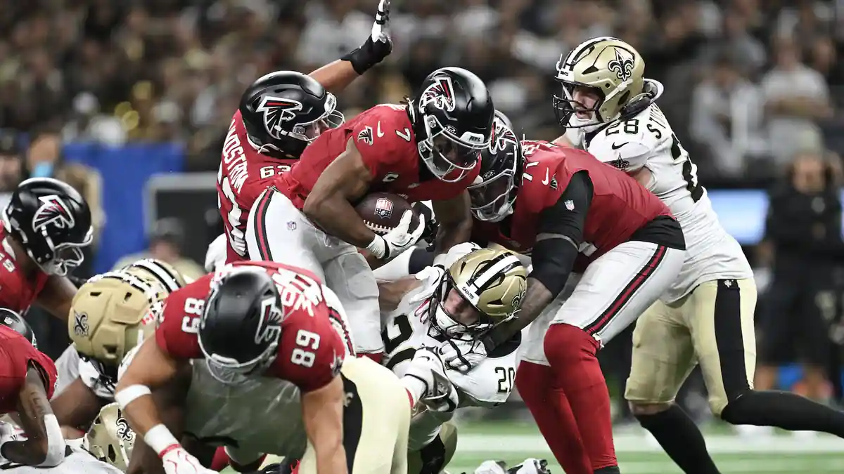 Atlanta Falcons players tackle a New Orleans Saints ball carrier during an NFL game