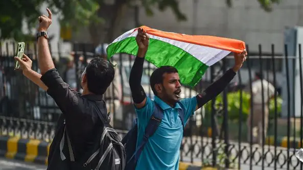 A protester holds the Indian flag during the protest in Delhi